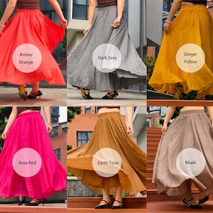 May include: A collection of six long, flowing skirts with elastic waistbands, presented in various solid colours including amber orange, dark grey, ginger yellow, rose red, earth tone brown, and khaki, each featuring a full, flared silhouette.