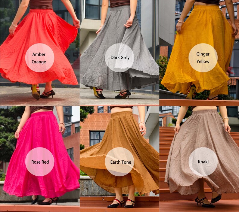 May include: A collection of six long, flowing skirts with elastic waistbands, presented in various solid colours including amber orange, dark grey, ginger yellow, rose red, earth tone brown, and khaki, each featuring a full, flared silhouette.