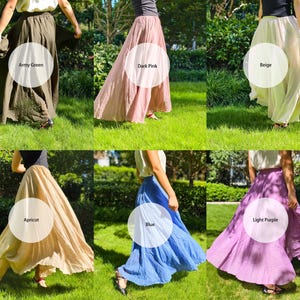 May include: A collection of six long, flowing skirts in various colours including army green, dark pink, beige, apricot, blue, and light purple. Each skirt features a gathered waistline and a full, flared silhouette that reaches the ankles.