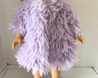 May include: A lavender fuzzy doll coat for a 18-inch doll. The coat is made of soft, fluffy fabric and has a simple design.