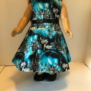 May include: A blue and black sleeveless dress with a black ribbon and a white "Harry Potter" print featuring the Hogwarts castle and other magical imagery.