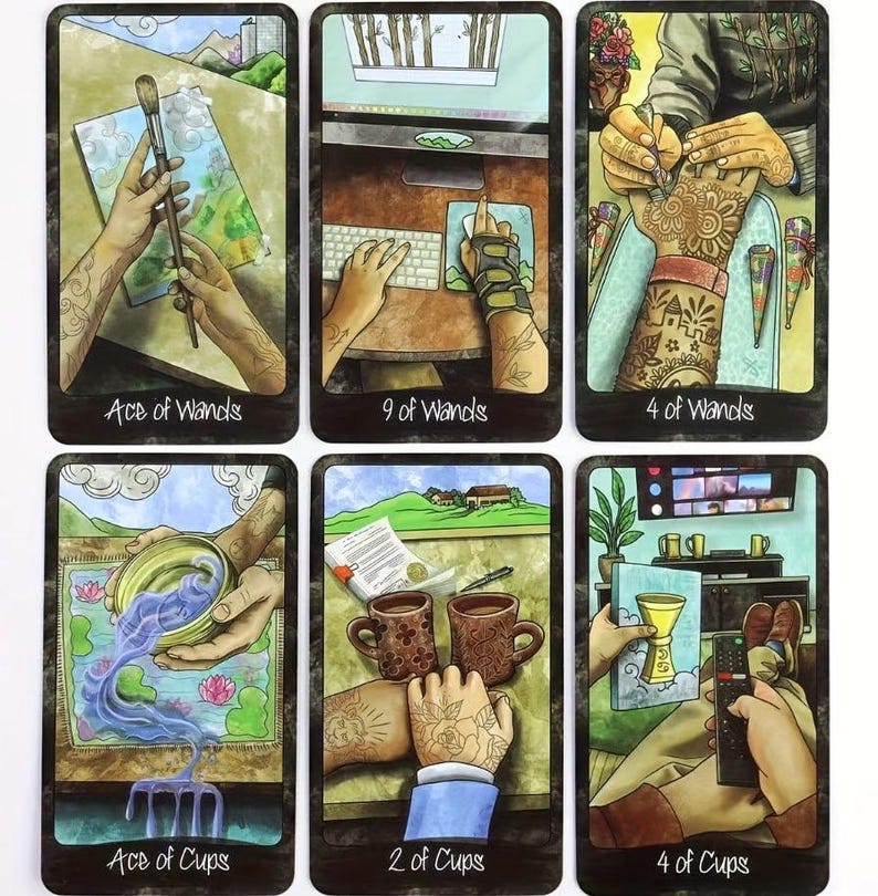 May include: A collection of six tarot cards with vibrant illustrations. The cards show hands interacting with objects like a paintbrush, a keyboard, and cups. Each card is labelled at the bottom with titles such as "Ace of Wands" and "4 of Cups".