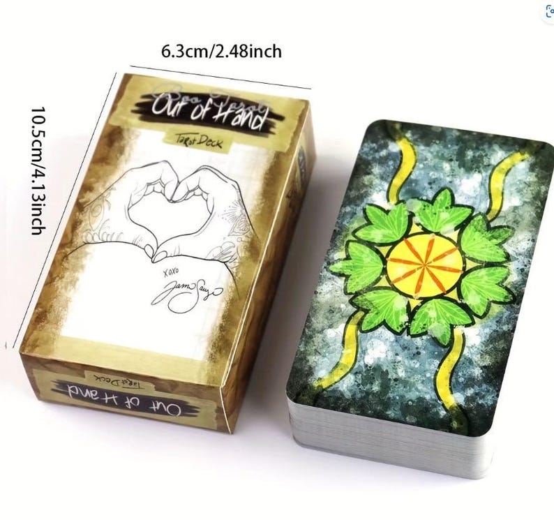 May include: A tarot deck with a box labelled "Out of Hand Tarot Deck." The box is 6.3cm wide and 10.5cm tall, with a design of hands forming a heart. The deck's back has a green and yellow floral design.