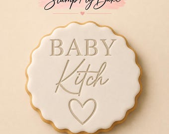 May include: A round scalloped cookie with smooth white icing featuring the embossed text BABY Kitch and a heart symbol below. Above the cookie, the text Stamp My Bake is displayed in black script with a small pink heart icon underneath.