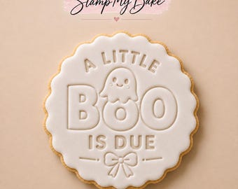 May include: A round scalloped cookie with white icing featuring the embossed text A LITTLE BOO IS DUE, a small ghost illustration, and a bow graphic. The Stamp My Bake logo is visible at the top of the image on a light tan background.