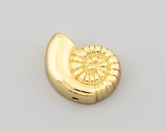 May include: A gold-colored, nautilus-shaped pendant. The pendant features a spiral design on one side and a smooth, curved surface on the other. The jewelry piece is set against a neutral background, highlighting its polished finish and intricate details.