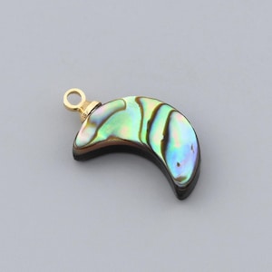May include: A crescent-shaped pendant with iridescent abalone shell inlay. The pendant has a gold-colored bail for attaching to a chain. The shell displays shades of green, blue, and black, creating a unique, eye-catching design.
