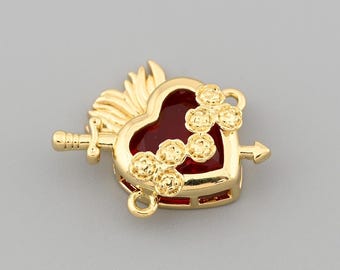 May include: A gold-colored heart-shaped charm with a red enamel center, adorned with small flower-like embellishments. A sword pierces the heart, and small loops are attached for jewelry making. The charm has a detailed, ornate design.