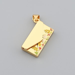 May include: A gold-colored pendant in the shape of an envelope. The pendant features a floral design with red, yellow, and green accents on the lower right corner. The pendant has a small loop at the top for a chain.