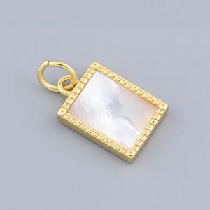 May include: A gold-colored rectangular pendant with a mother-of-pearl inlay. The pendant has a textured border and a small loop for attaching to a chain. The pendant is approximately 0.75 inches square.