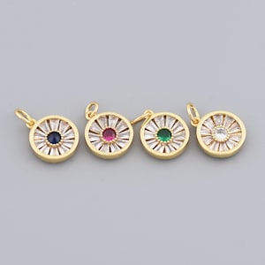 May include: Four gold-colored round pendants with a central gemstone and surrounding baguette-cut crystals. The gemstones are blue, red, green, and clear. Each pendant has a small loop at the top for attaching to a chain or bracelet.
