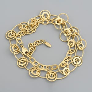 May include: Gold-toned necklace featuring a series of interconnected geometric shapes and oval links. The necklace has a lobster clasp closure and an extender chain. The design incorporates hexagonal and circular elements, creating a delicate and intricate pattern.