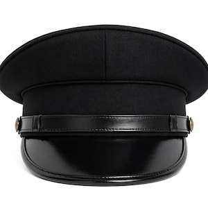 May include: A black hat with a rounded top and a shiny, curved brim. A black leather band with gold-colored buttons encircles the hat. The hat is a classic style, suitable for various occasions.