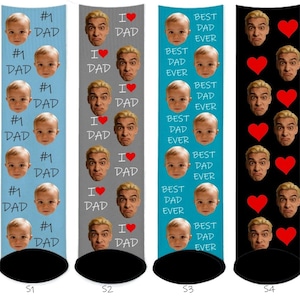 May include: Four pairs of socks with various designs. One pair features "#1 DAD" and a baby's face, another says "I ❤️ DAD" with a man's face, a third says "BEST DAD EVER" with a baby's face, and the last has hearts and a man's face.