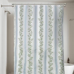 May include: A striped shower curtain with vertical light blue stripes and white stripes. Green leafy vines with small white flowers run vertically down the curtain. The curtain is hanging in a bathroom with a white tub and shower fixtures.