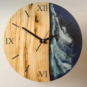 Op de afbeelding: Ronde houten wandklok met een gesplitst ontwerp. De ene helft is lichtgekleurd hout met zwarte Romeinse cijfers en zwarte wijzers. De andere helft heeft een blauw en wit harsontwerp, dat lijkt op oceaangolven.