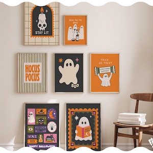 May include: A collection of seven framed wall art prints featuring Halloween themes, including ghosts, a skull candle with the text STAY LIT, HOCUS POCUS, a ghost holding a sign saying EMOTIONAL SUPPORT, and various spooky icons like cats and bats.