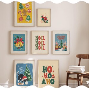 May include: A gallery wall set of seven framed Christmas-themed art prints featuring illustrations of holiday cookies, Santa Claus, golden bells, a Christmas market, a cat with a tree, and festive typography reading NOEL and HO HO HO.