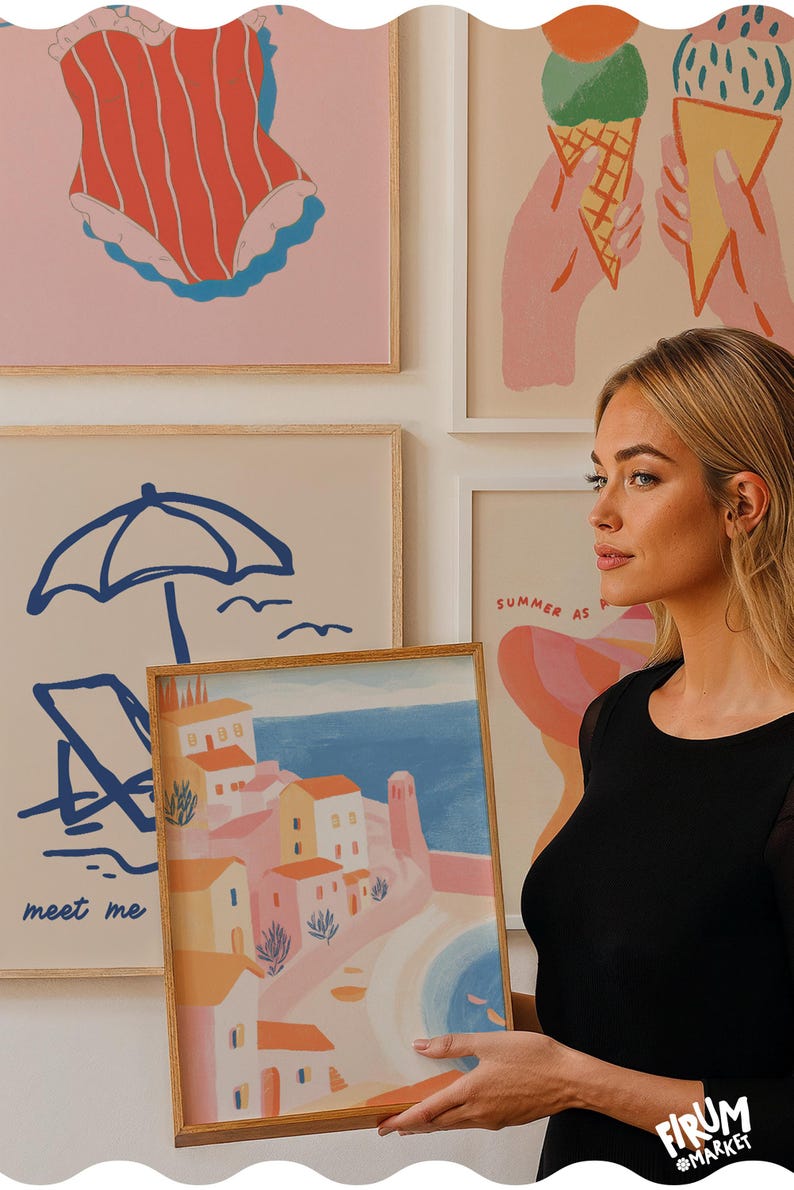 May include: A framed art print featuring a coastal town scene with buildings in shades of pink, orange, and white, set against a blue sea and sky. Other prints in the background depict summer-themed illustrations, including a swimsuit, ice cream cones, and beach elements.
