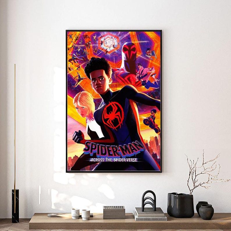 Może przedstawiać: Oprawiony plakat filmowy Spider-Man: Across the Spider-Verse. Grafika przedstawia Milesa Moralesa w czarno-czerwonym kostiumie Spider-Mana, z Gwen Stacy i innymi postaciami w tle. Plakat ma czarną ramę i jest wyświetlany na białej ścianie.
