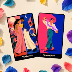 Könnte beinhalten: Zwei rechteckige Tarotkarten mit den Titeln The Lovers und Temperance. Die Karte The Lovers zeigt zwei Figuren in rosa und weißer Kleidung vor einem rosa-blauen Hintergrund. Die Karte Temperance zeigt eine Figur, die violette Flüssigkeit gießt.