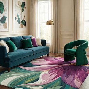 May include: A living room scene featuring a teal sofa with decorative pillows, a green armchair, and a large floral rug with shades of pink, purple, and green. A gold floor lamp and framed botanical art complete the decor.