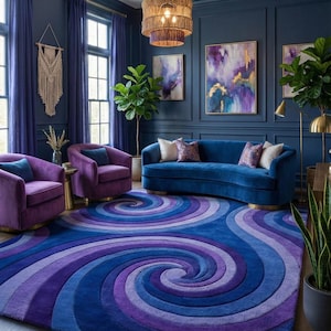 May include: A large area rug featuring a prominent blue and purple spiral pattern. The rug is placed in a room with dark blue walls, two purple armchairs, a curved blue sofa, gold accents, and abstract wall art with purple and gold tones.