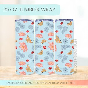 May include: Three 20 oz tumbler wraps with a light blue background, featuring a repeating pattern of orange butterflies, pink lotus flowers, gray flowers, and red ladybugs. The text "20 OZ TUMBLER WRAP" is at the top.