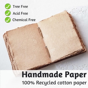 May include: Open handmade paper journal with a natural, textured appearance. The pages are held together with a simple binding. The text on the image reads "Tree Free", "Acid Free", "Chemical Free", "Handmade Paper", and "100% Recycled cotton paper".