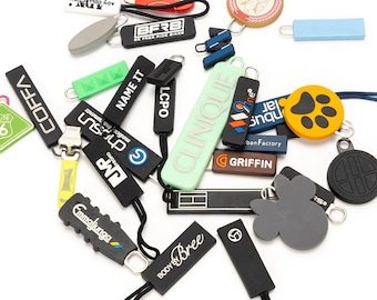 May include: A collection of colorful zipper pulls with various logos and designs, including "COFFA", "NAME IT", "LCPO", "BFRB", "CLINIQUE", "Griffin", "99", "MP", "Route 66", and "Body Bree".