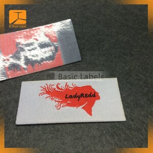May include: White woven label with red embroidered design of a woman's hair and the text "LadyRedd" in black.