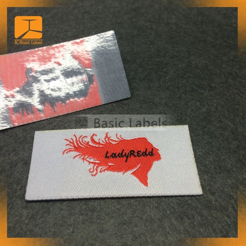 May include: White woven label with red embroidered design of a woman's hair and the text "LadyRedd" in black.