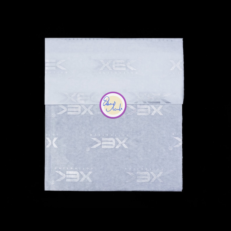May include: White tissue paper with a repeating pattern of the word "exclusive" in a stylized font. A purple circle with the word "Exclusive" written in cursive is in the center of the tissue paper.