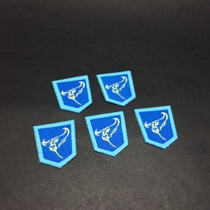 May include: Five blue and white embroidered patches with a bull's head design.