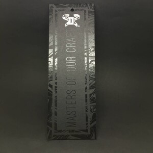 Pode incluir: Etiqueta preta e prateada com um padr&atilde;o geom&eacute;trico e o texto "Masters of Our Craft" em branco.