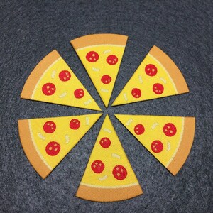 May include: Six yellow felt pizza slices with red pepperoni and white cheese. The slices are arranged in a circle on a gray background.