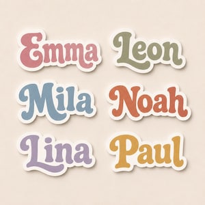 Könnte beinhalten: Sechs gestanzte Aufkleber mit Namen in einer wellenförmigen, fetten Schriftart. Die Namen sind Emma in Rosa, Leon in Olivgrün, Mila in Staubblau, Noah in Terrakotta-Orange, Lina in Lavendel und Paul in Senfgelb, jeweils mit einem weißen Rand.
