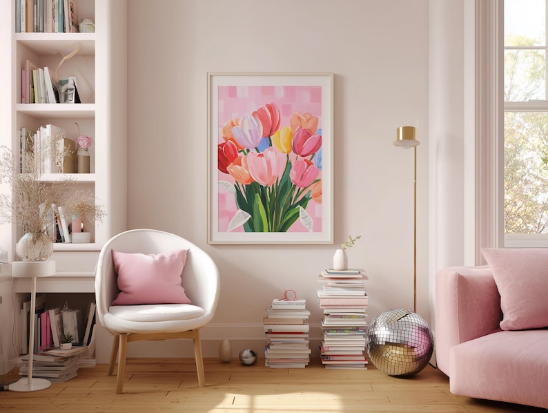 floral art print featuring a bouquet of colorful tulips in shades of pink, red, yellow, and blue. The artwork is displayed in a light-filled room with a white chair, pink pillow, and a pink sofa. A disco ball and stacks of books add decorative elements.
