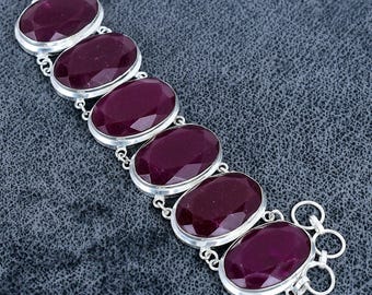 Puede incluir: Una pulsera de plata con seis piedras preciosas ovaladas de color rojo intenso. Las piedras están engastadas en biseles individuales de plata y conectadas por eslabones de plata. La pulsera tiene un cierre de palanca.
