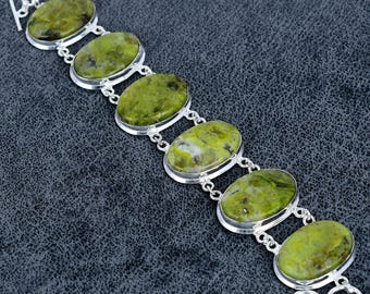 Pode incluir: Uma pulseira de prata com pedras preciosas ovais verde-oliva. As pedras são engastadas em biséis individuais de prata e unidas por pequenos conectores de prata. Fecho de alternância. Comprimento aproximado: 19 cm.