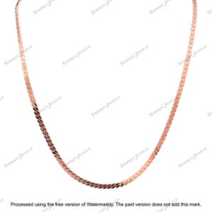 Könnte beinhalten: Eine Halskette aus Roségold mit Fischgrätenmuster. Die Halskette hat ein flaches, gewebtes Design, das eine glatte, reflektierende Oberfläche erzeugt. Die Kette wird vor einem weißen Hintergrund präsentiert, der ihre Farbe und Textur hervorhebt. Ein schlichtes, elegantes Schmuckstück.