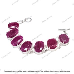 May include: A silver bracelet featuring oval-cut, deep red gemstones. The gemstones are set in individual silver bezels and connected by small silver links. The bracelet has a toggle clasp. The text "SAMRAT JEWELS" is watermarked across the image.