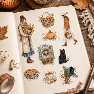 May include: A collection of autumn-themed stickers featuring a person holding flowers, a basket of apples, a person walking with a basket, a pumpkin, a window with a wreath, a black cat, a pie, a teacup with cookies, and a mailbox with fall leaves.
