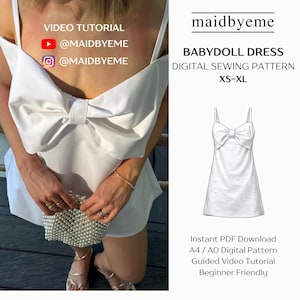 May include: A white babydoll dress with a large bow detail. The image includes text that reads "VIDEO TUTORIAL @MAIDBYEME" and "BABYDOLL DRESS DIGITAL SEWING PATTERN XS-XL". A drawing of the dress is also shown.