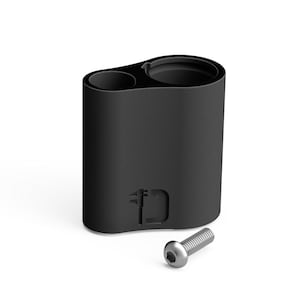 May include: A black cylindrical object with two openings, one small and one larger, and a silver screw. The object has a textured surface and a small design etched into the side. The screw is lying next to the object.