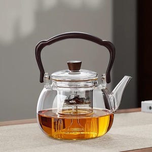 May include: A set of three ceramic mugs with a speckled, matte finish in cream, light brown, and dark brown. Each mug has a simple, minimalist design and a rounded handle.