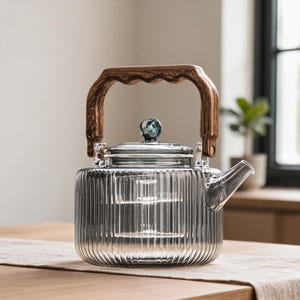 May include: A clear glass teapot with a vertical ribbed texture, featuring a dark brown wood-grain patterned handle and a matching lid knob. The teapot includes a transparent internal glass infuser basket and a short, angled pouring spout.