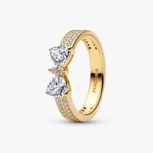 May include: A white ceramic mug with a black handle and the text "But First, Coffee" in a bold, black font. The mug is set against a blurred background, suggesting a cozy setting. The mug appears to be approximately 4 inches tall.