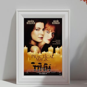 Puede incluir: Un póster enmarcado de la película "Practical Magic" con Sandra Bullock y Nicole Kidman. El póster tiene una paleta de colores cálidos con imágenes de velas y siluetas. El texto "PRACTICAL MAGIC" se muestra de forma destacada.