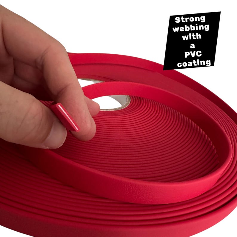 Op de afbeelding: Een rol felrood singelband met een PVC-coating. De tekst "Strong webbing with a PVC coating" wordt weergegeven op een zwarte achtergrond. Het singelband wordt door een hand vastgehouden.